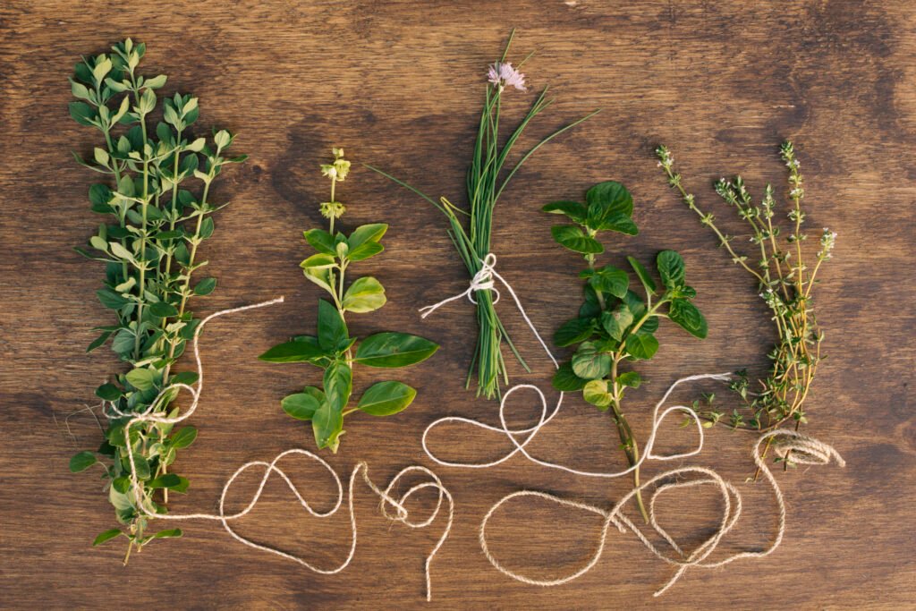 Fresh herbs like basil, parsley, mint, and cilantro displayed on a kitchen table
